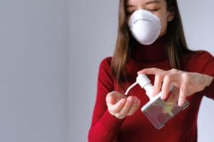 woman putting sanitizer on hands